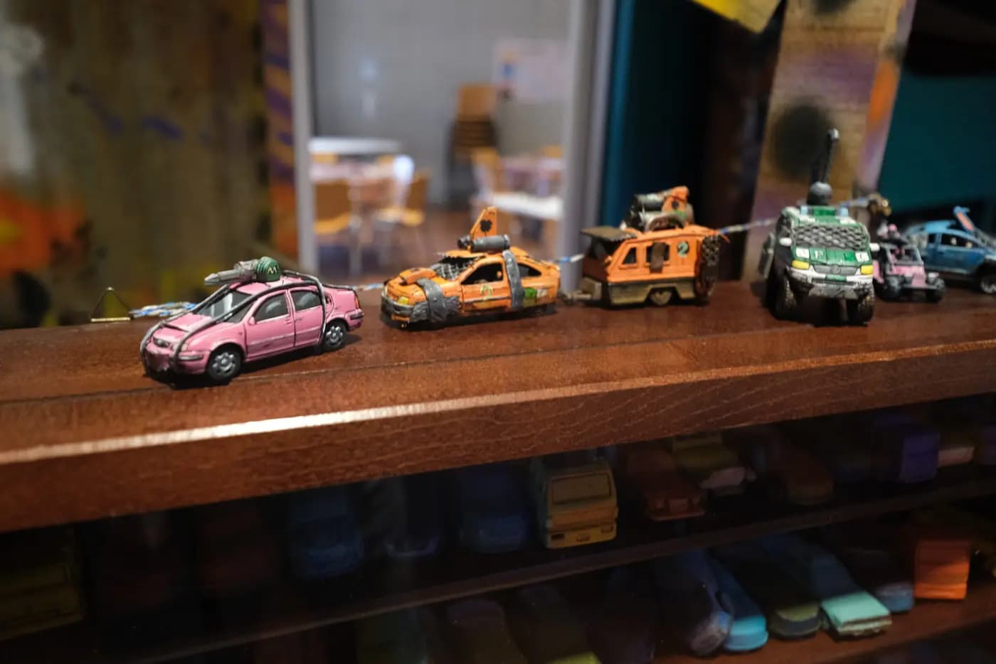 Des petites voitures de Gaslands customisées, alignées sur une étagère.